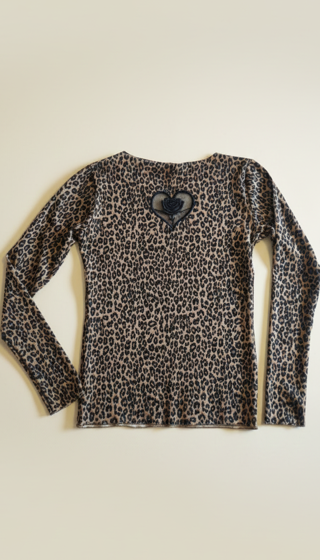 Leopard print long-sleeve shirt with a black heart design on a beige background