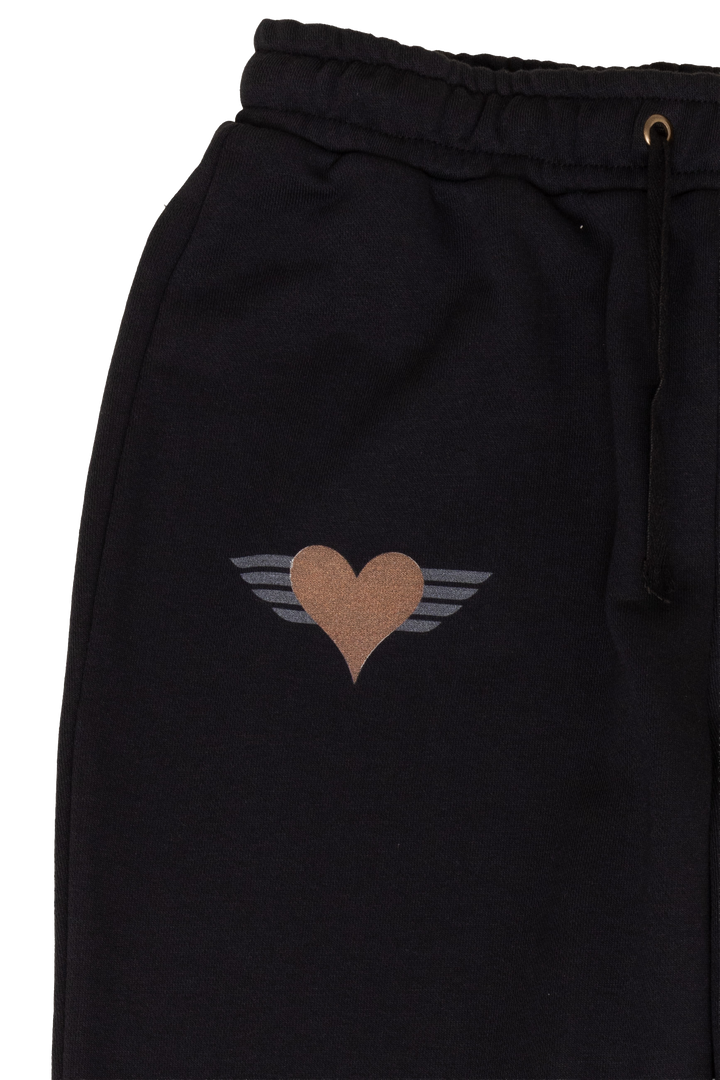 Black pants with a heart and wings design on a white background