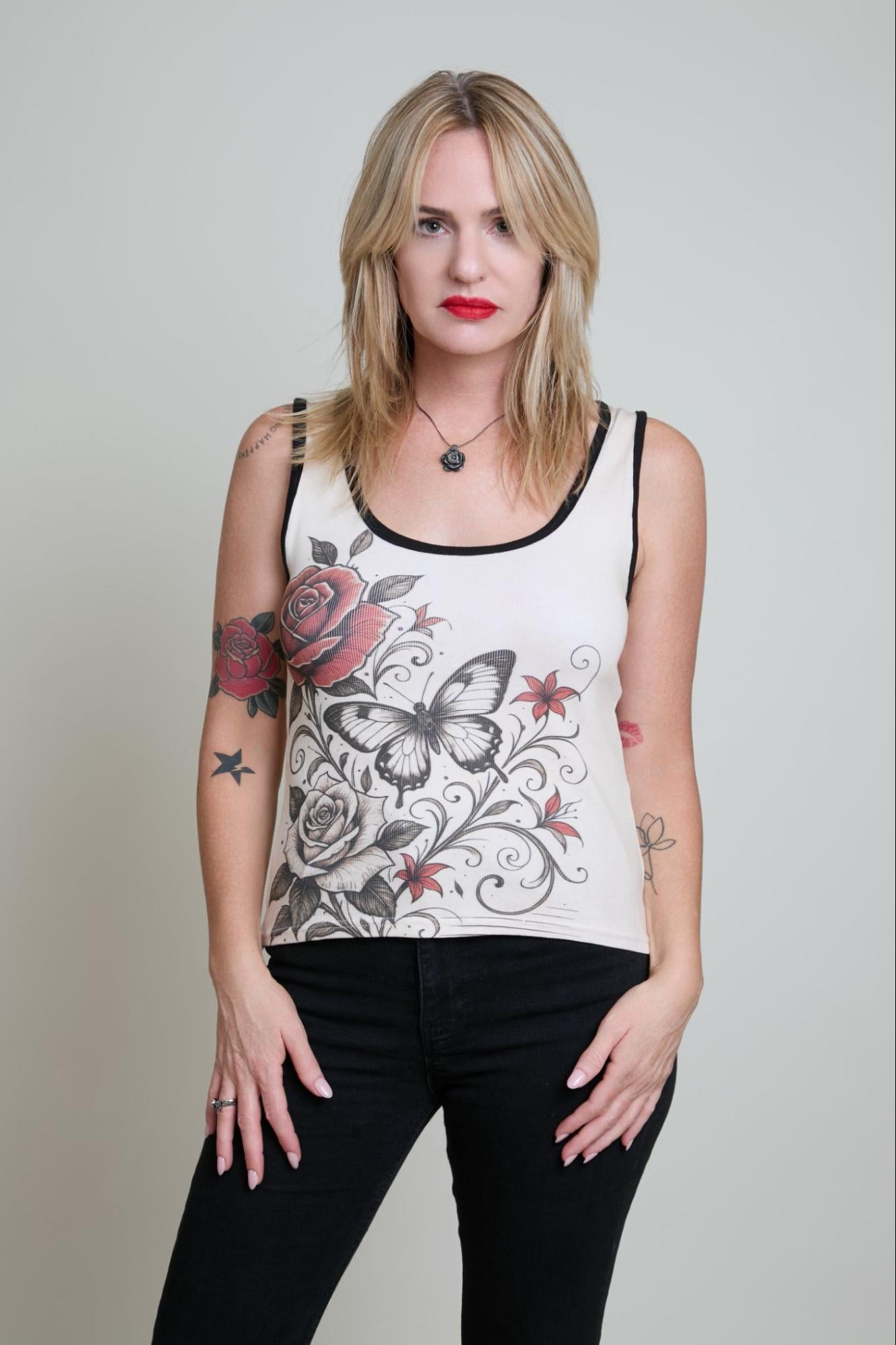 Woman wearing a sleeveless top with floral and butterfly design on a plain background