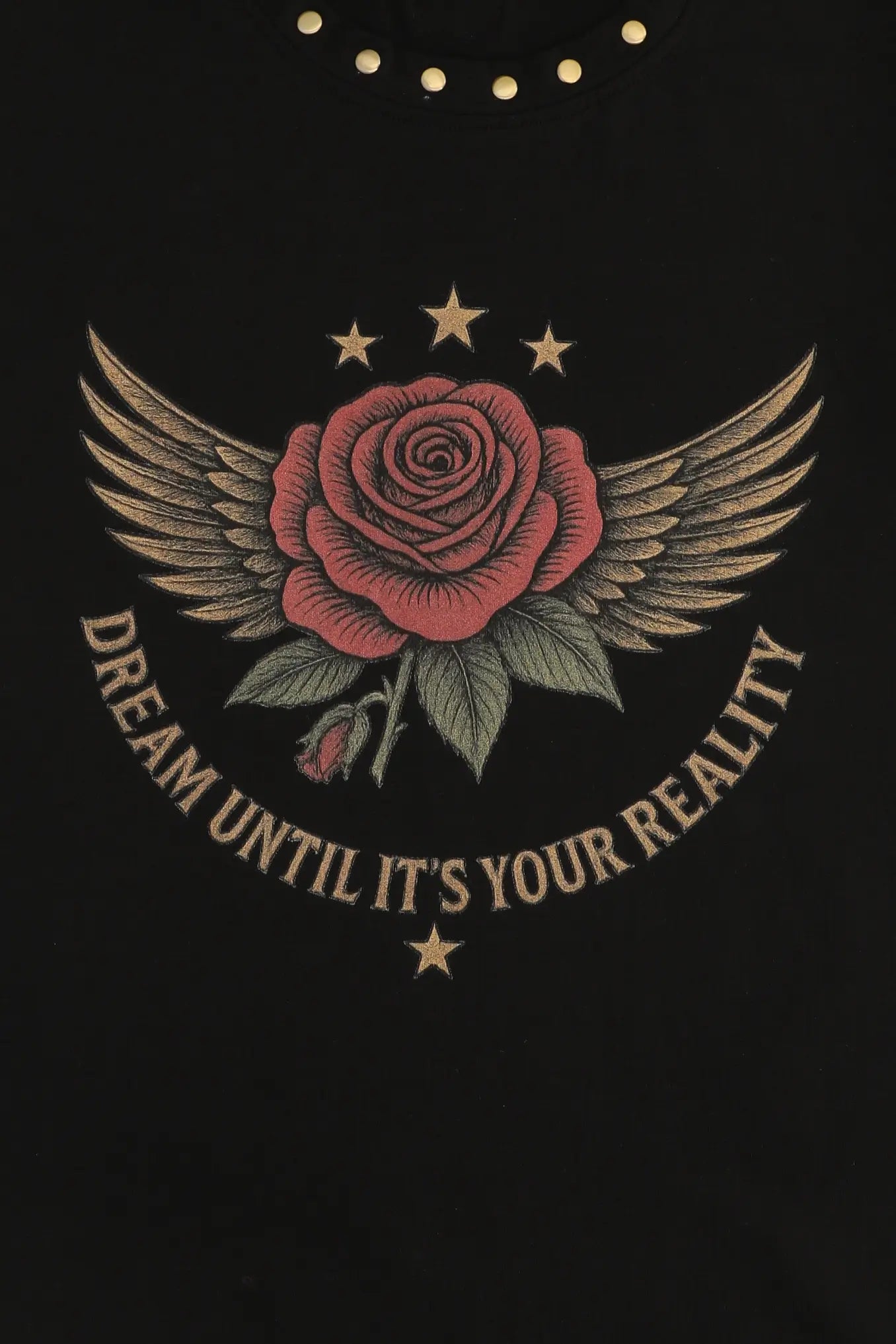 Embroidered rose with wings and stars on a black background with 'Dream Until It's Your Reality' text.