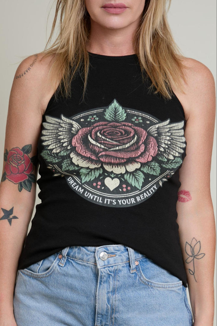 Person wearing a black tank top with a rose and wings design, standing against a neutral background.