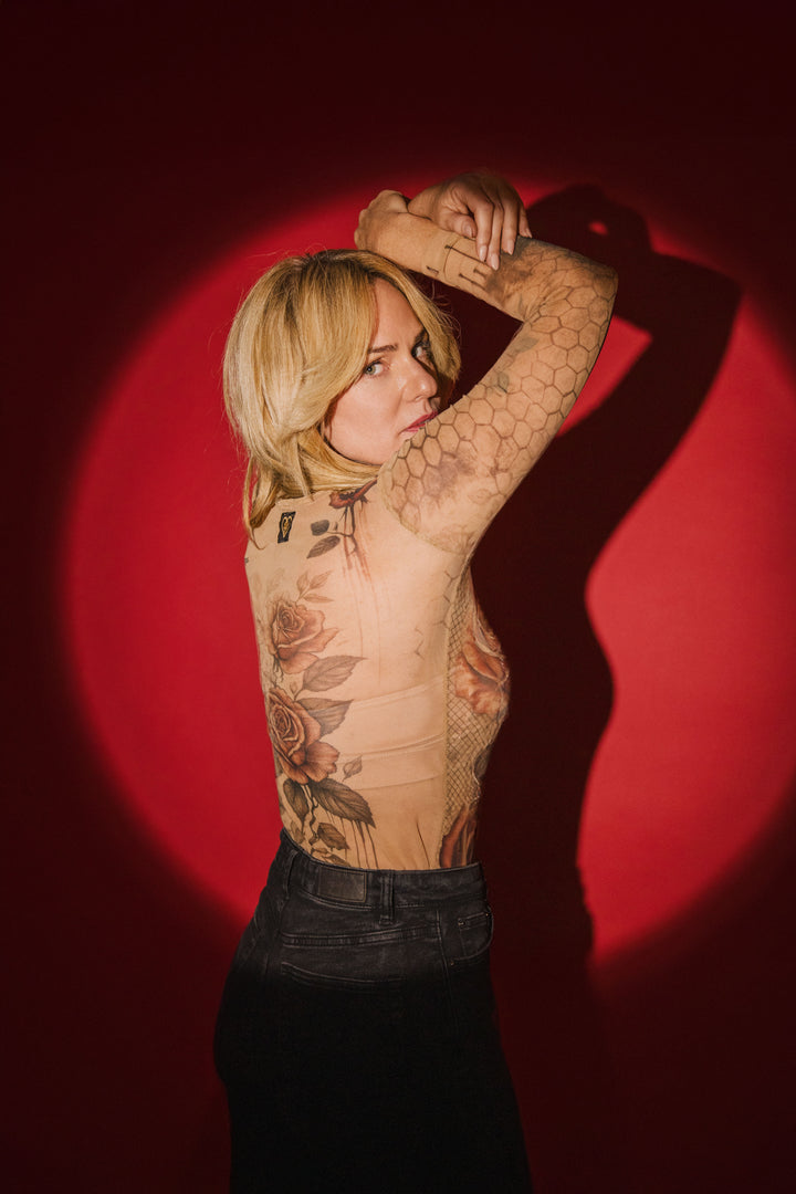 Person with tattoos on a red background