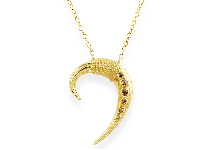 Gold crescent moon necklace with embedded stones on a white background