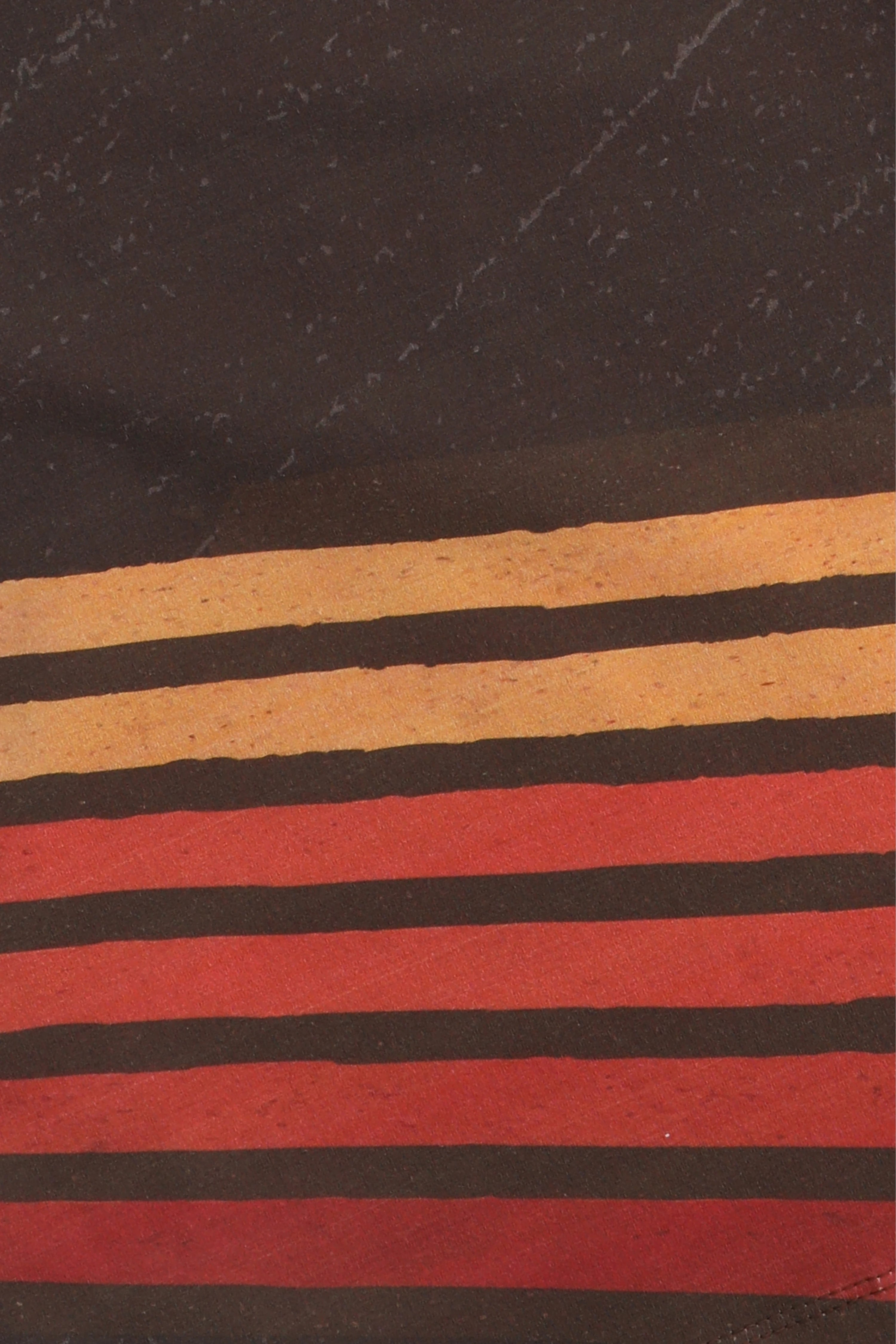 Close-up of fabric with horizontal stripes in brown, black, and red on a dark background.