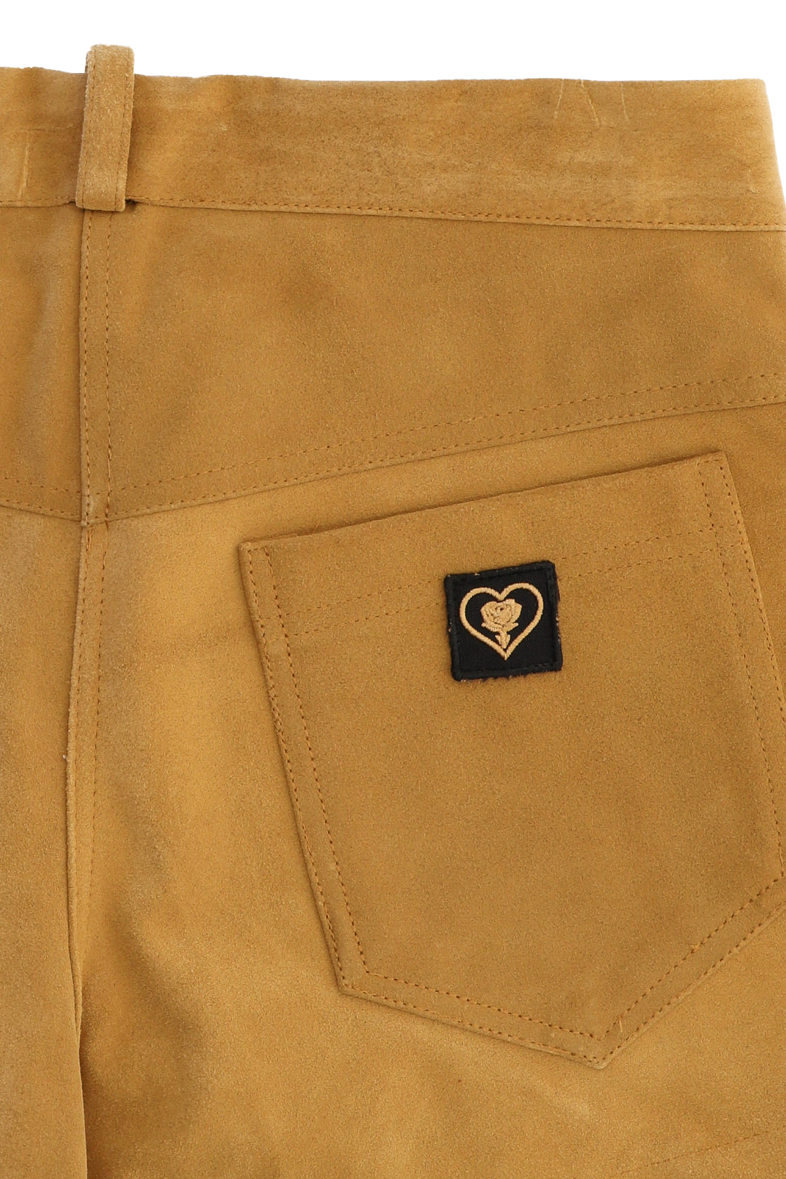 Close-up of a brown pants pocket with a heart-shaped logo tag.