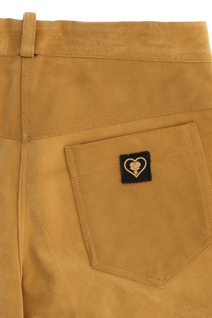 Close-up of a brown pants pocket with a heart-shaped logo tag.