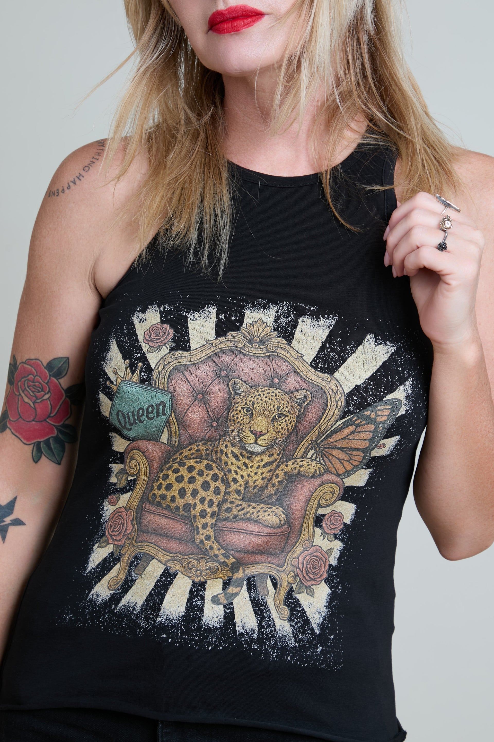 Person wearing a black tank top with a leopard design on a white background
