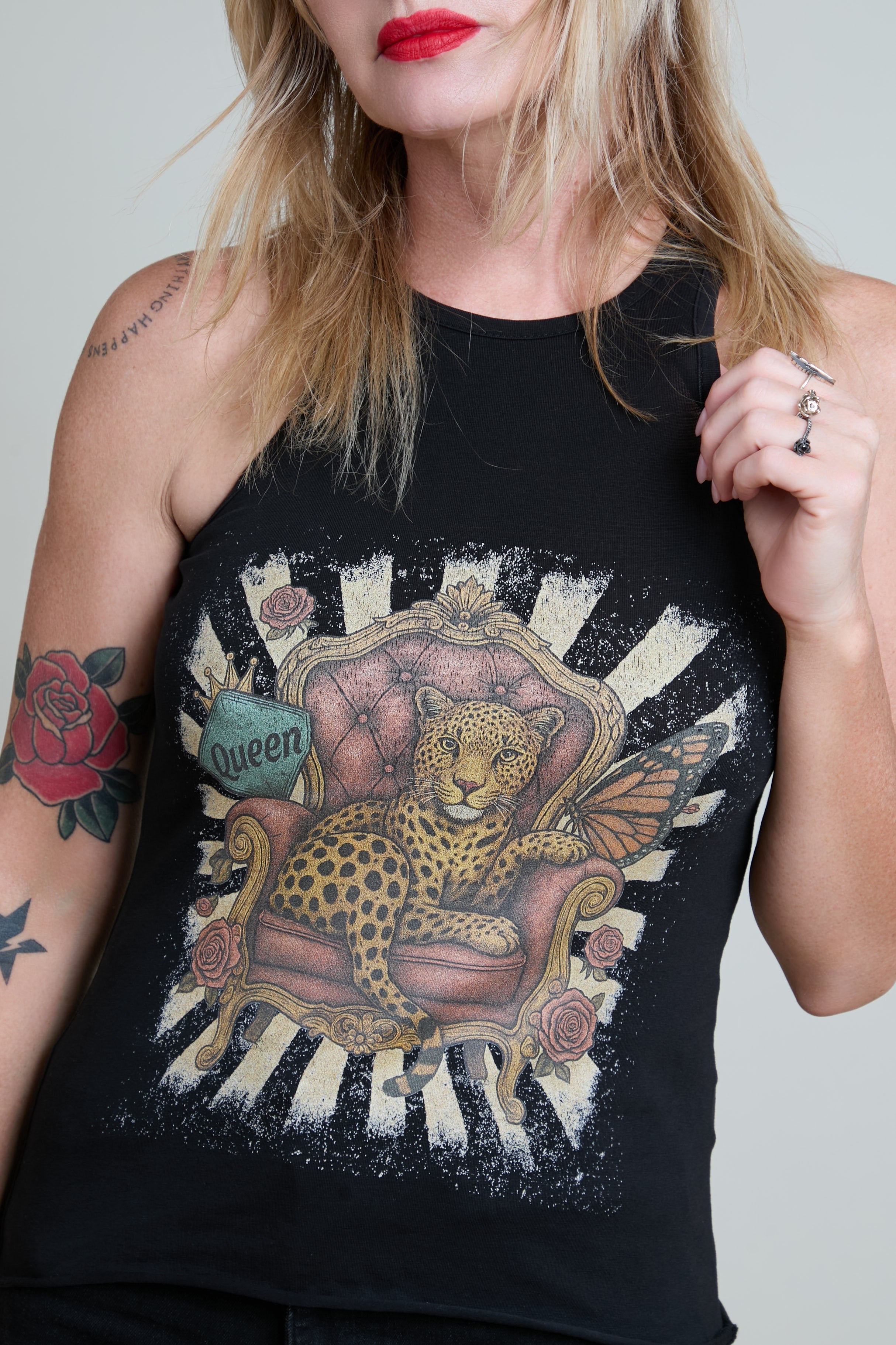 Person wearing a black tank top with a leopard design on a white background