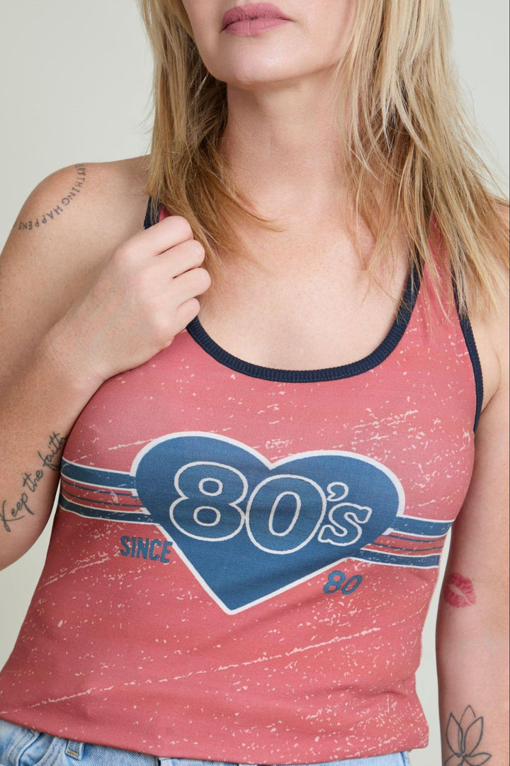 Person wearing a red tank top with '80s since 80' design.