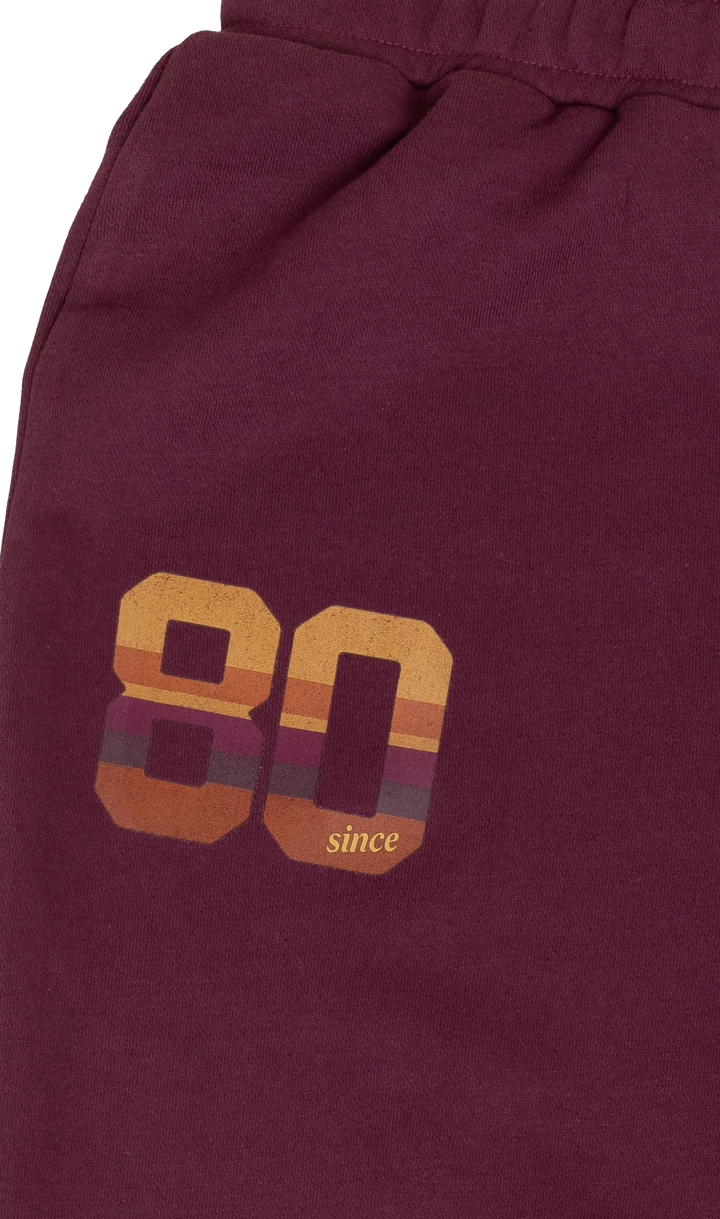 Maroon shorts with '80 since' text and design on a maroon background