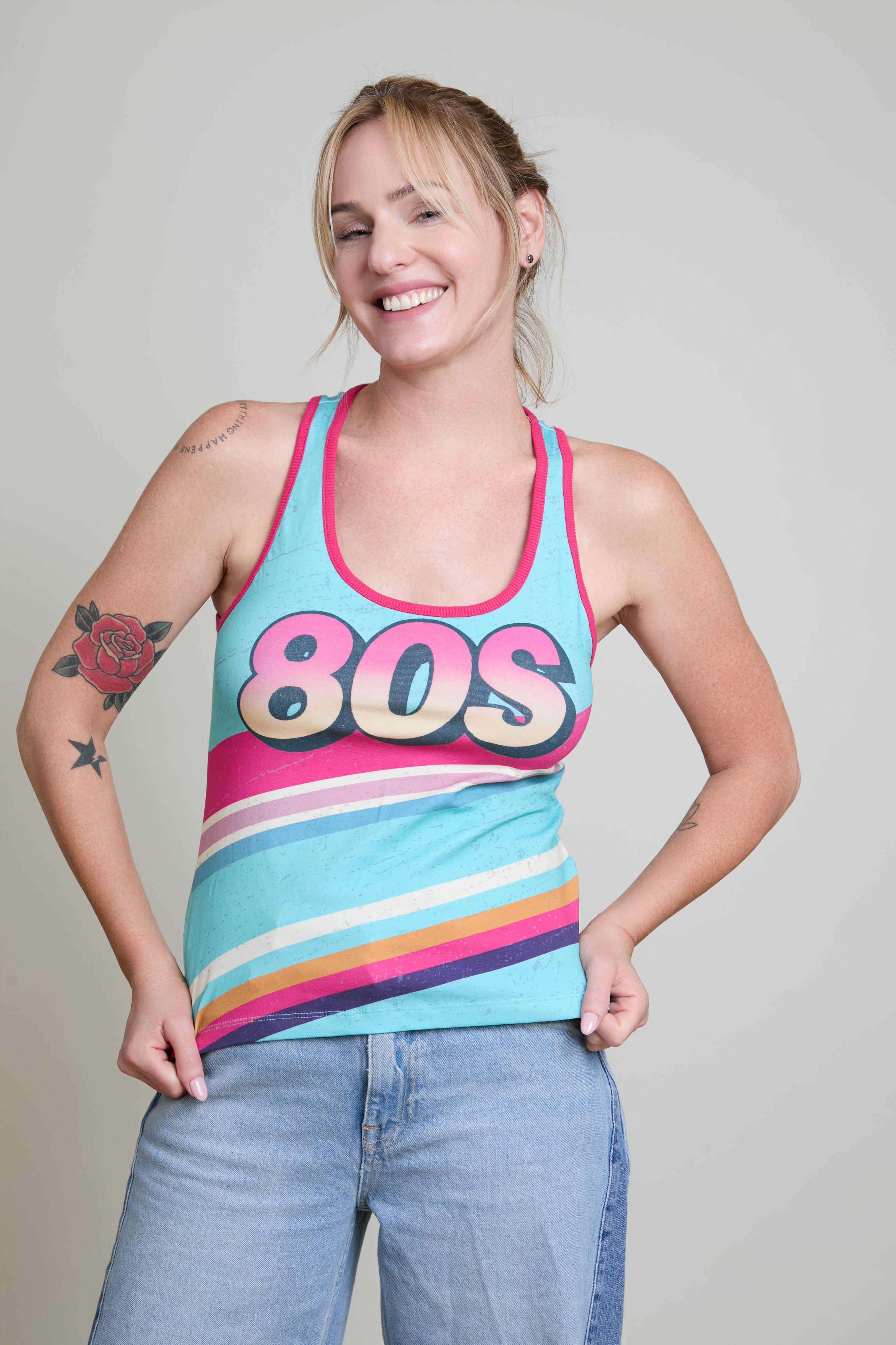 Woman wearing a colorful '80s' tank top against a plain background
