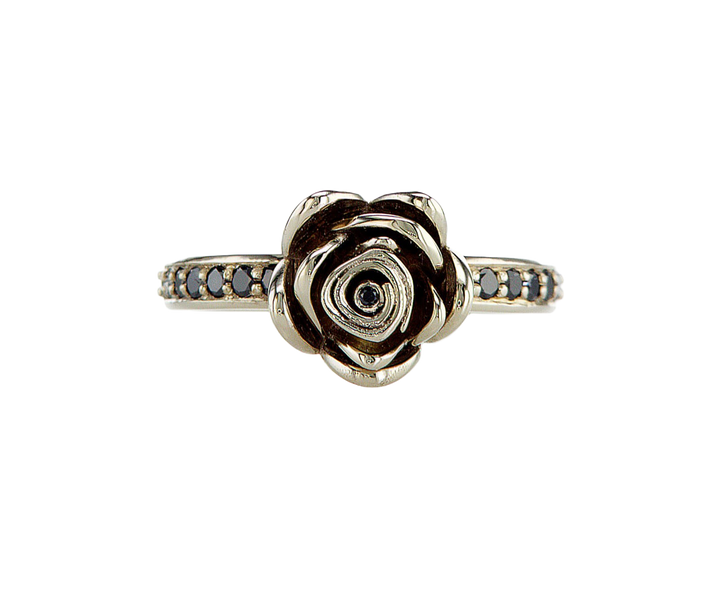 Gold rose-shaped ring with black gemstones on a white background