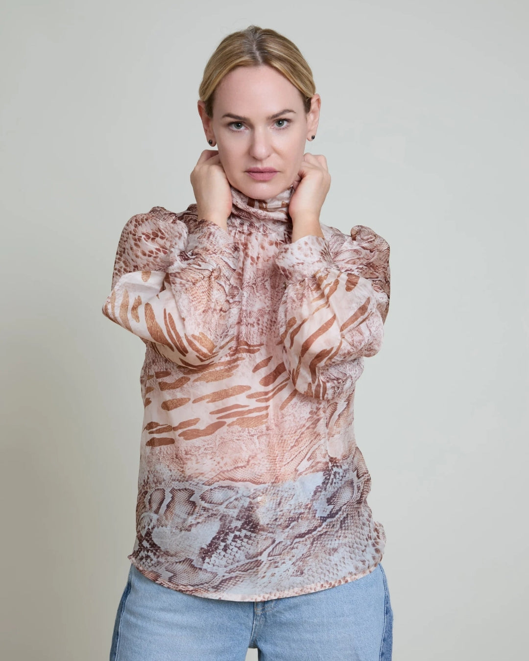 Woman wearing a patterned blouse with a plain background