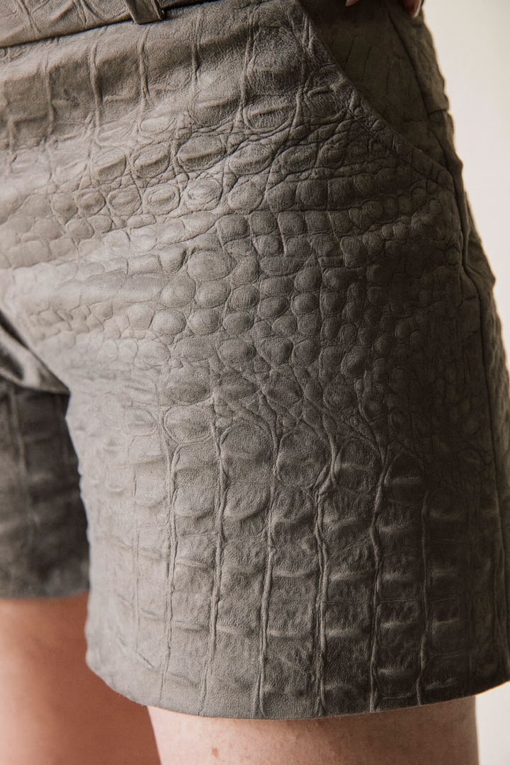 Close-up of textured gray shorts on a plain background