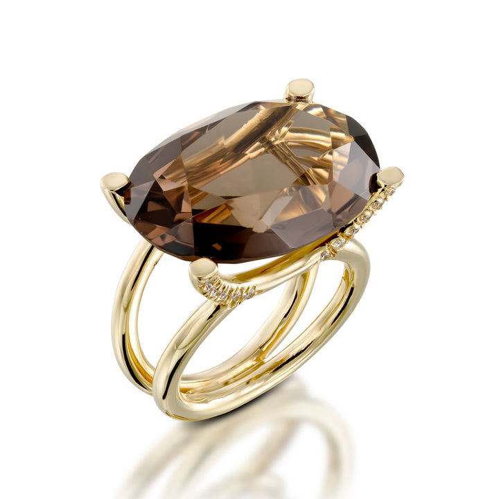 Gold ring with a large brown gemstone on a white background
