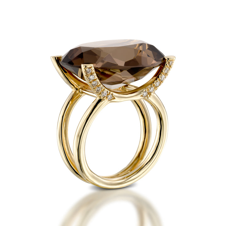 Gold ring with a large brown gemstone on a white background