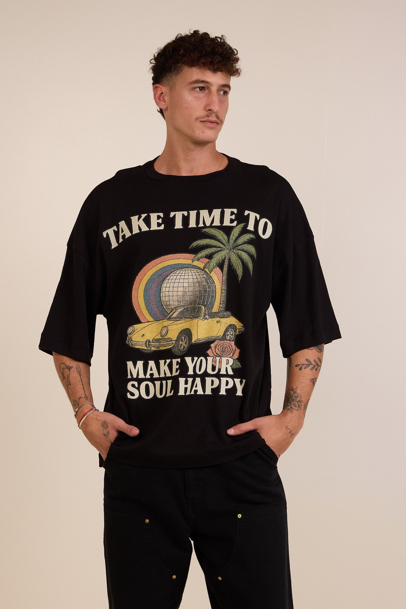 Person wearing a black t-shirt with a graphic design and text on a beige background