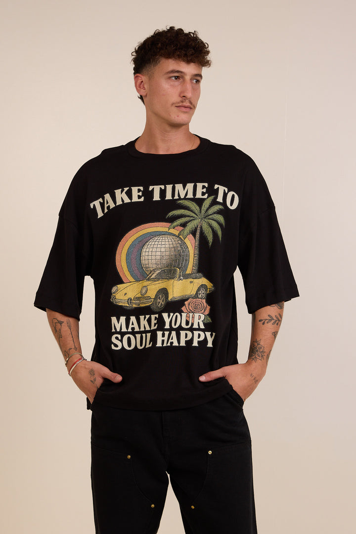 Person wearing a black t-shirt with a graphic design and text on a beige background