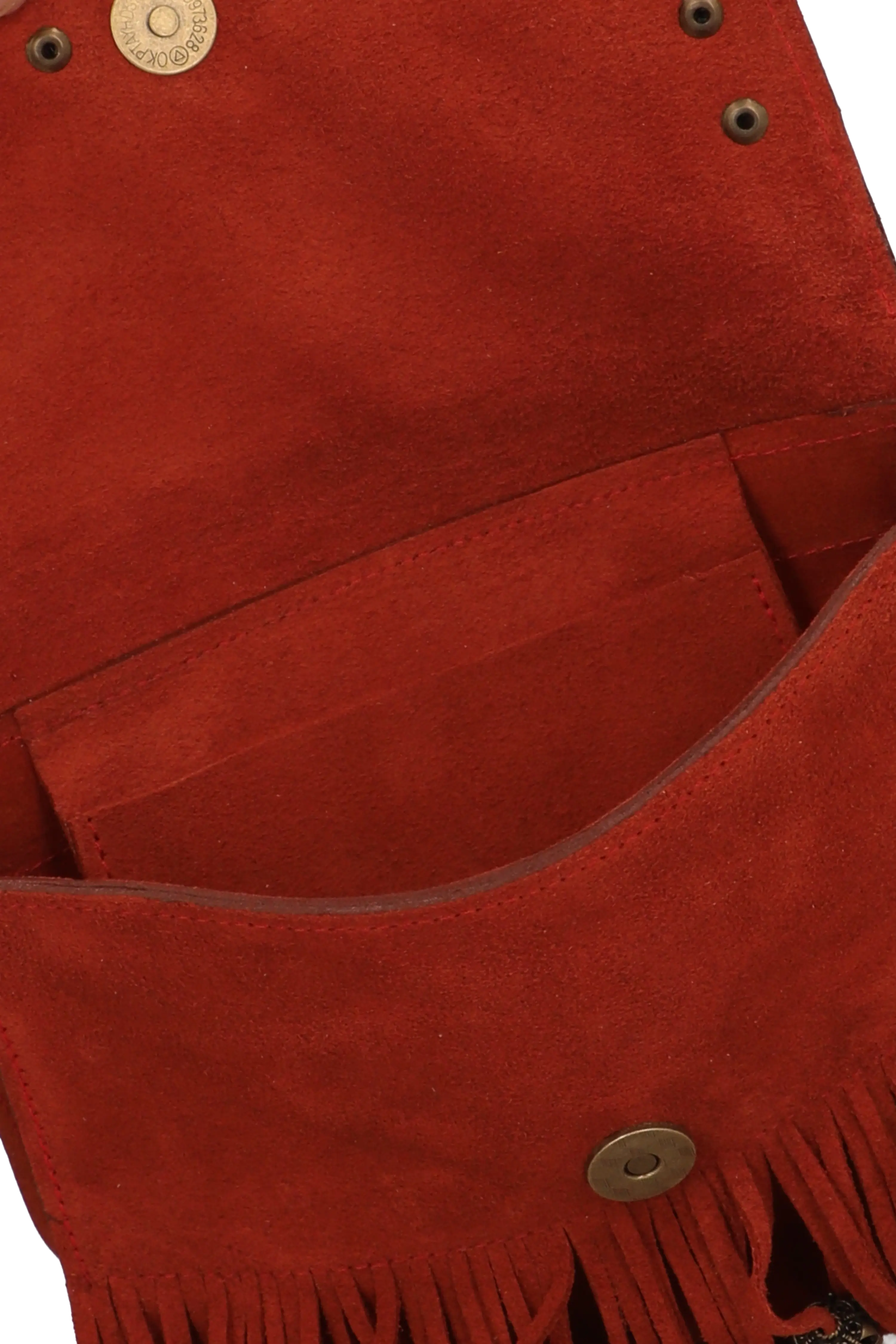 Close-up of a red suede bag with fringes and metal buttons on a white background