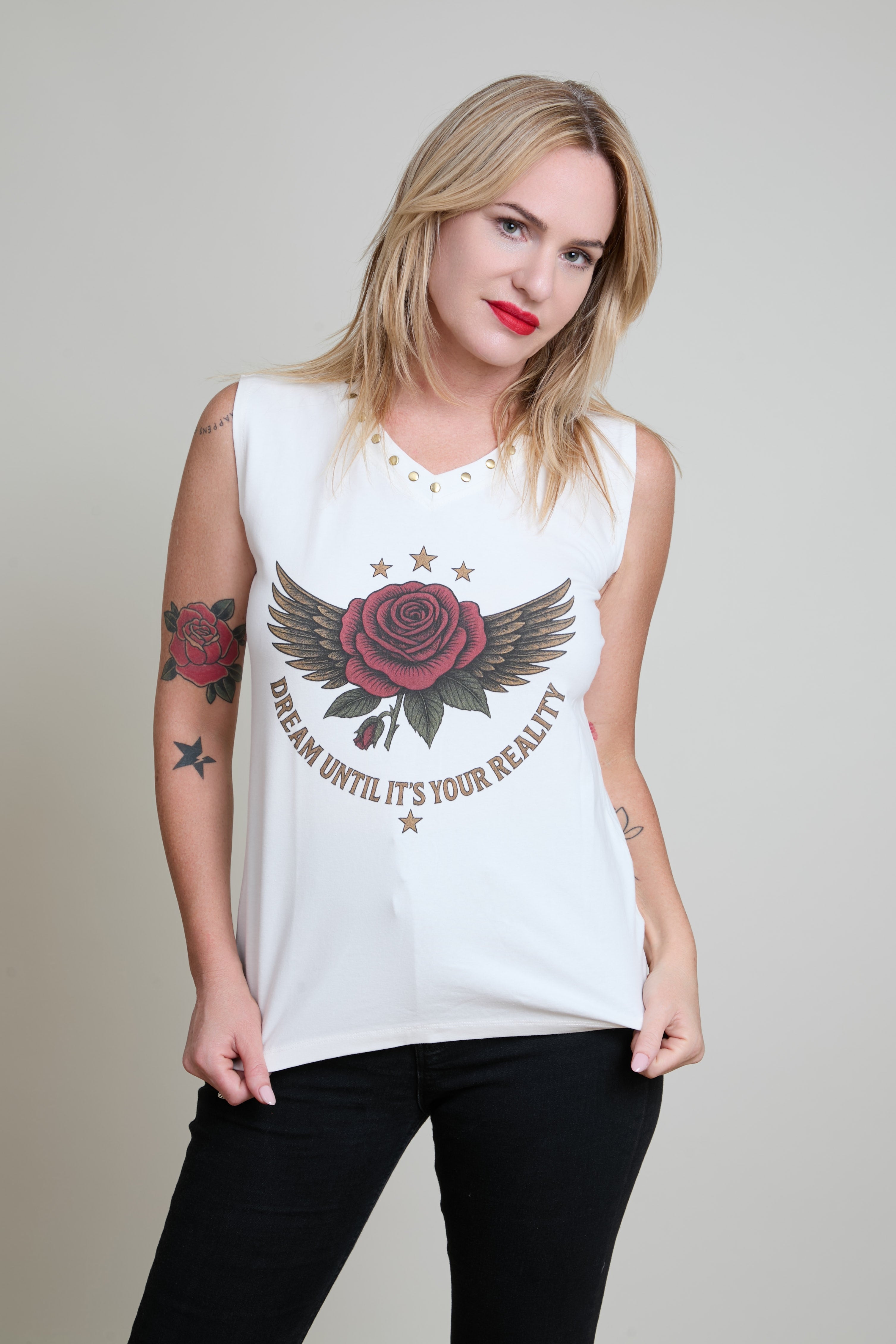 Woman wearing a purple top and blue jeans against a plain background