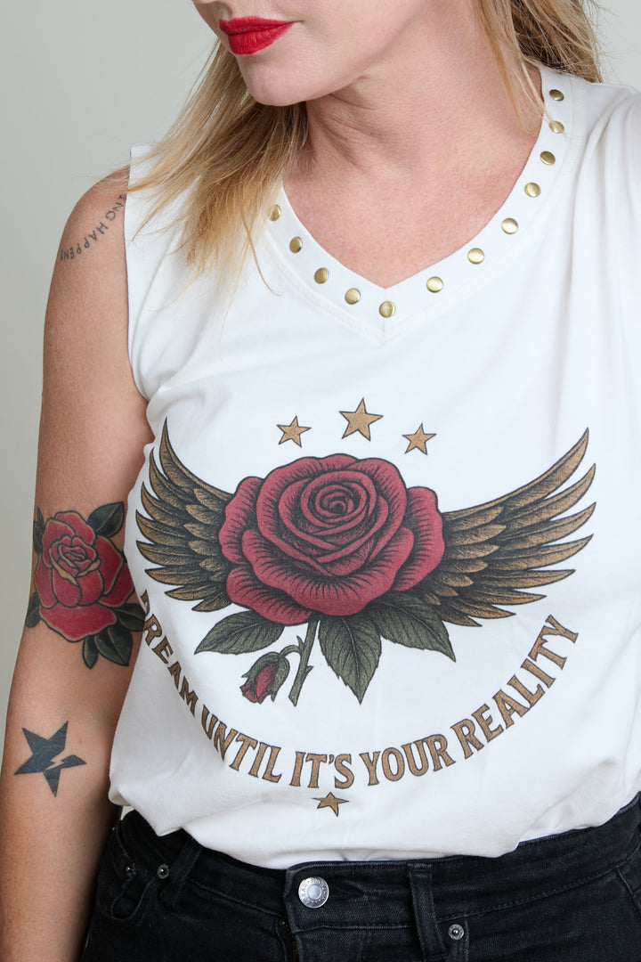 White sleeveless shirt with red rose and wings design and text, worn by a person.
